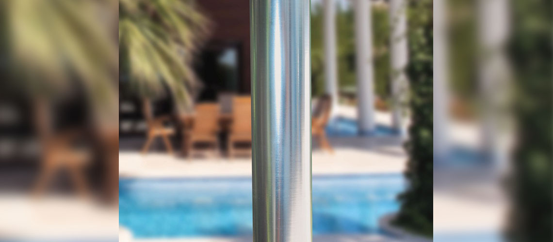 Closeup of an Aluminum Umbrella Pole with Pool and Outdoor Furniture in the Background